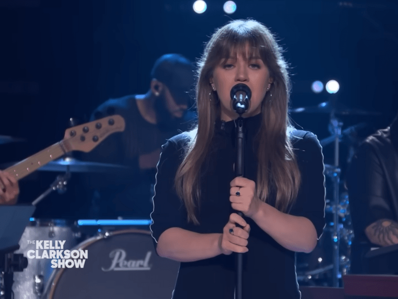 Kelly Clarkson wearing a black dress on stage