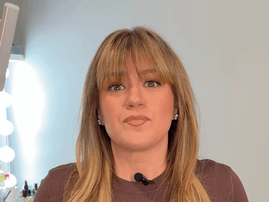 Kelly Clarkson wearing a brown sweater