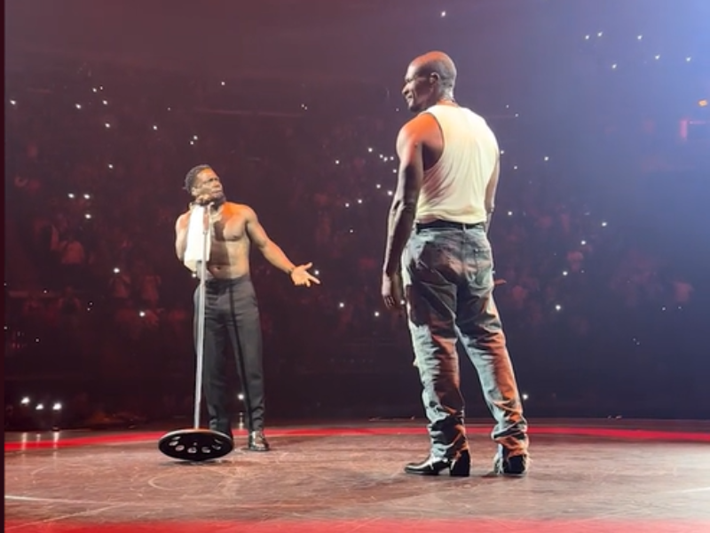 Kevin Hart performing on stage with Usher