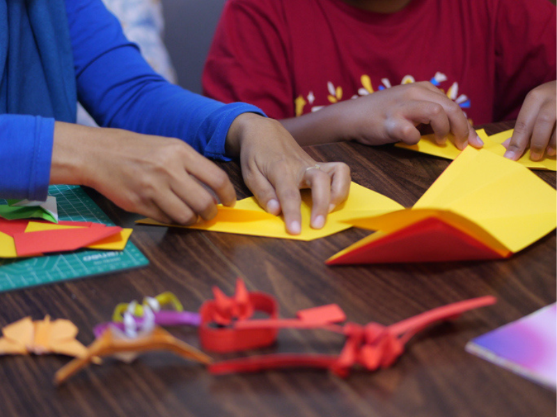 Kids doing paper crafts on a table