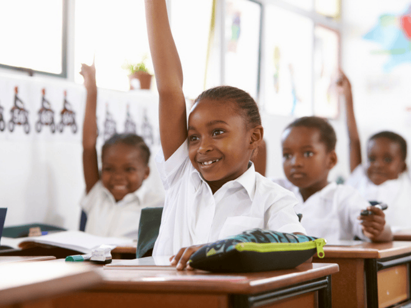Kids raising hands during a lesson inside a classroom