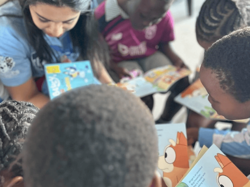 Kids reading Bluey books in class with a volunteer