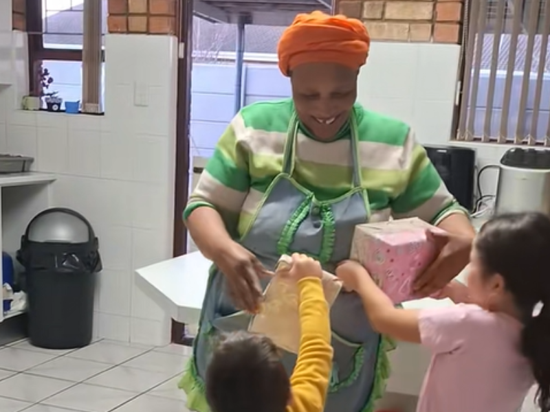 Children rush over to their domestic helper holding birthday gifts