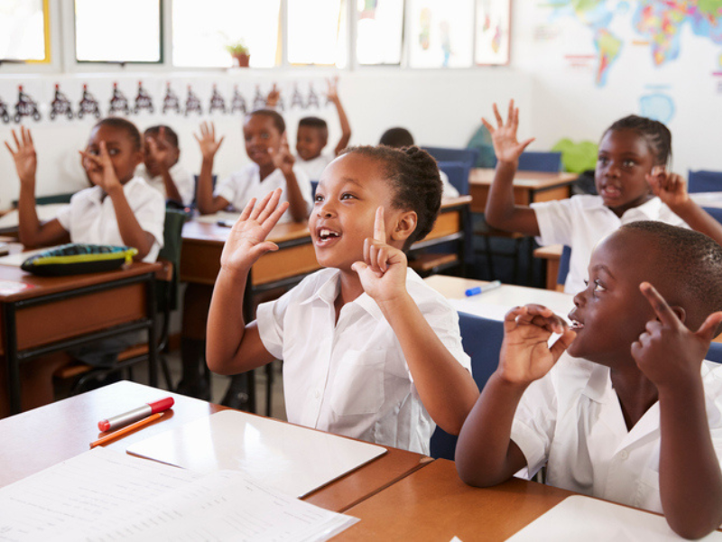 Kids showing hands during a lesson at an elementary