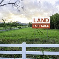 Land for sale sign on empty land