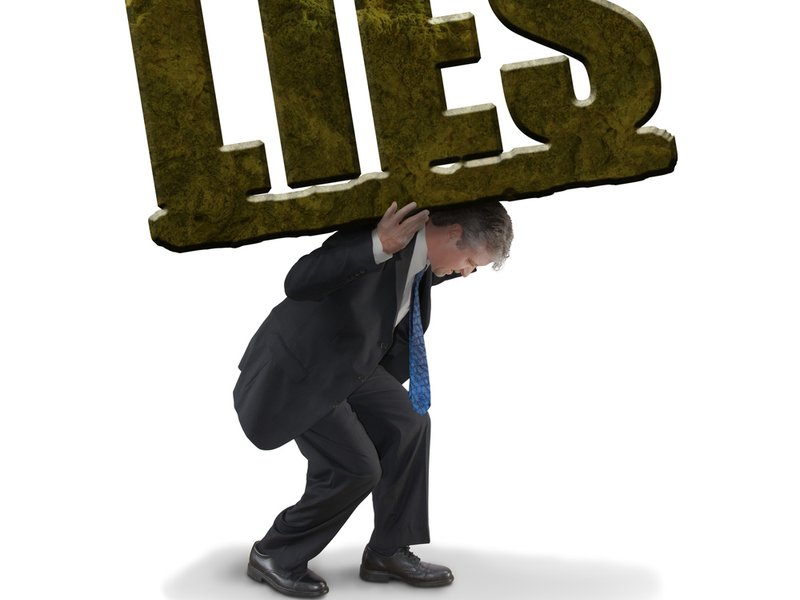Man struggling to carry heavy stone lies
