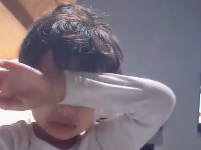 Little boy wiping his tears with his arm