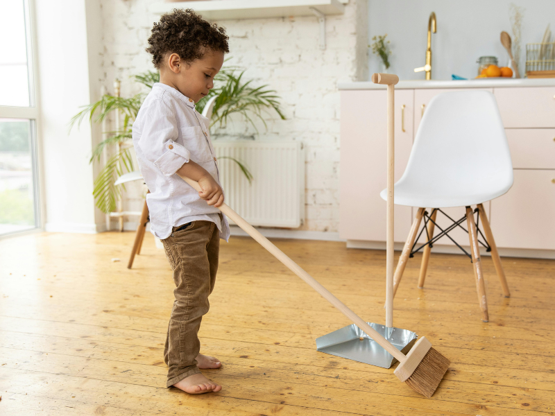 Little kid sweeping the floor