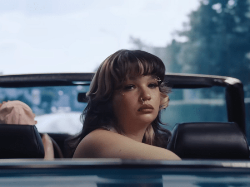 Lola Young sitting in the backseat of a car