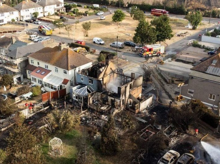Houses ablaze as grass fire engulfs village outside London.