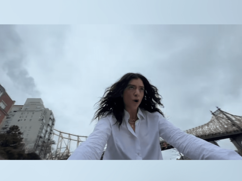 Lorde rides a bike on an overcast day