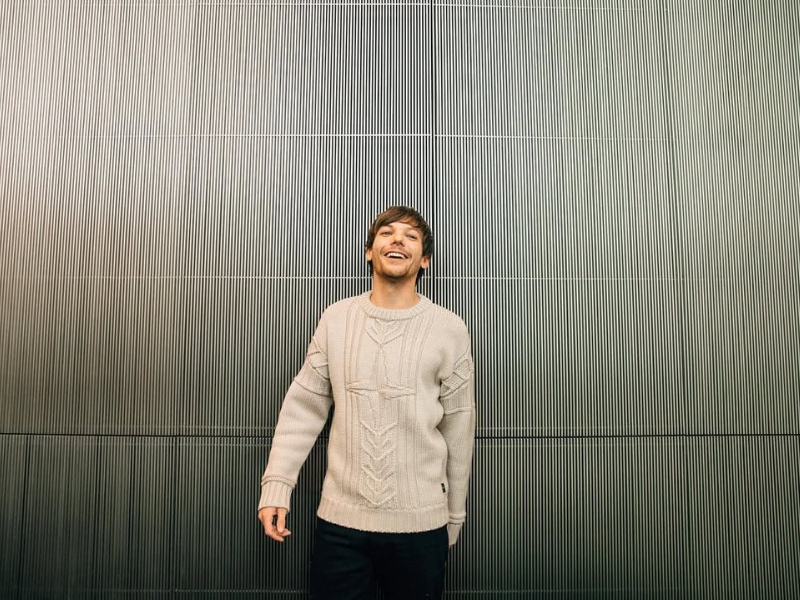 Louis Tomlinson wearing a cream coloured jersey