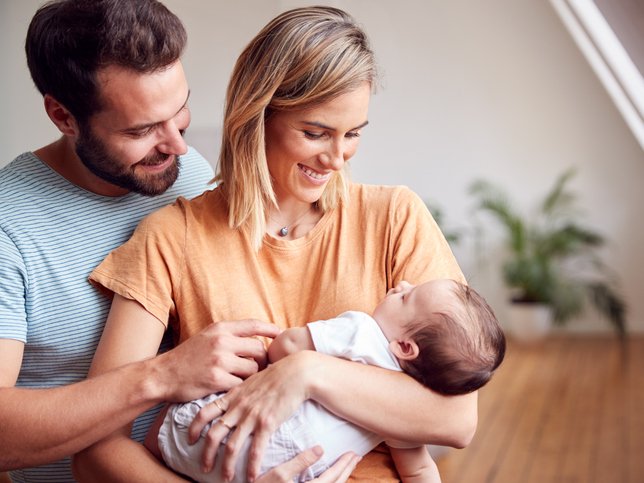 Loving Parents Holding Newborn Baby At Home