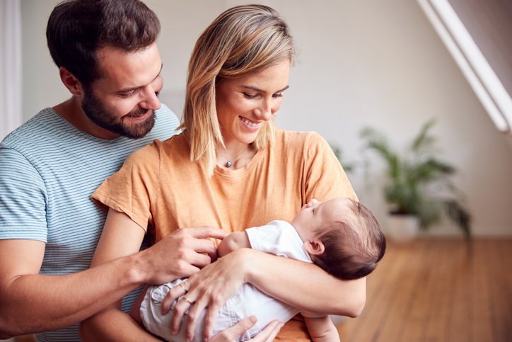 Loving Parents Holding Newborn Baby At Home