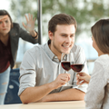 MAN AND WOMAN ON DATE WOMAN SPYING