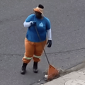 MUNICIPAL WORKER SWEEPING LITTER DOWN DRAIN