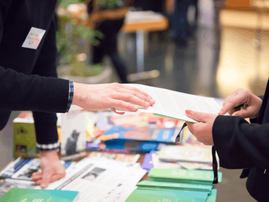 Man and woman sharing information leaflet over exhibition stand