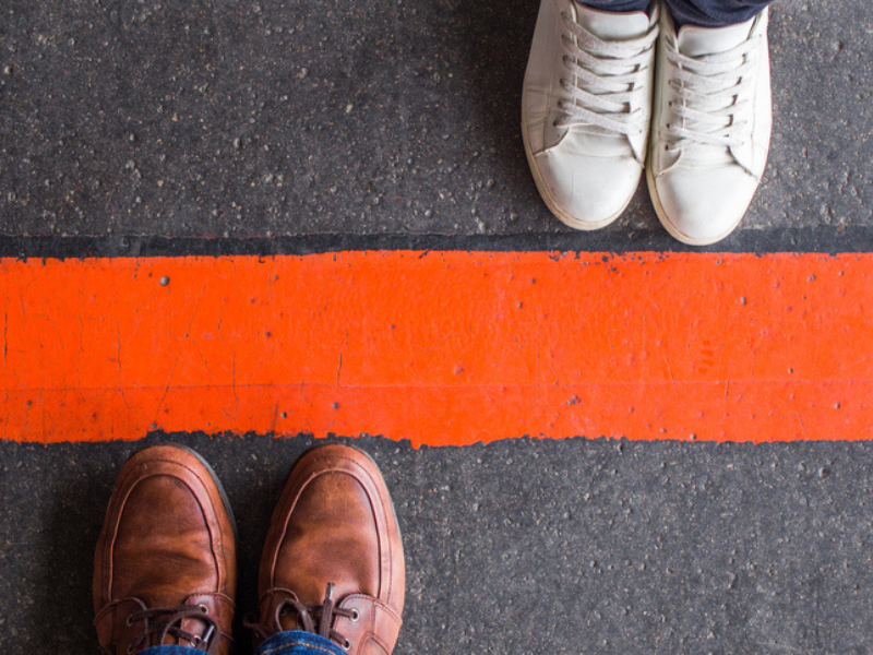 Man and woman shoes divided by a line to indicate boundaries