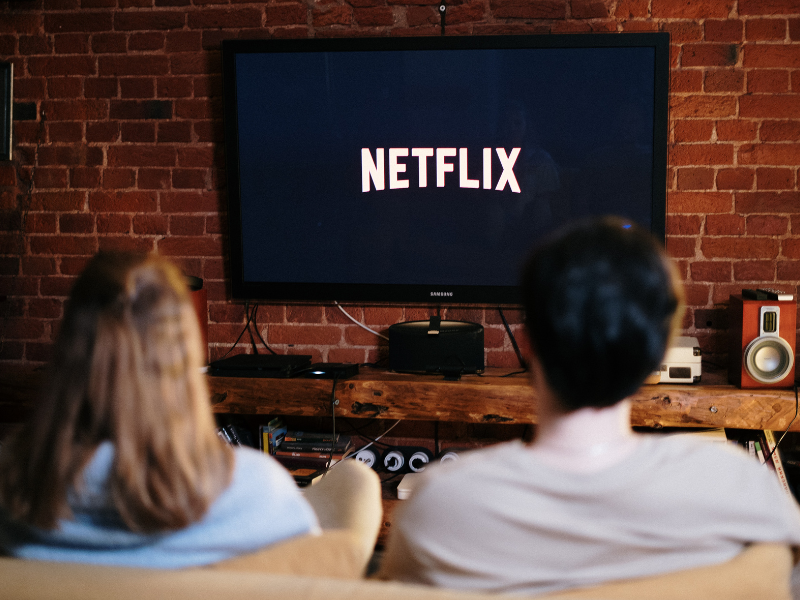 Man and woman sitting on a couch in front of television