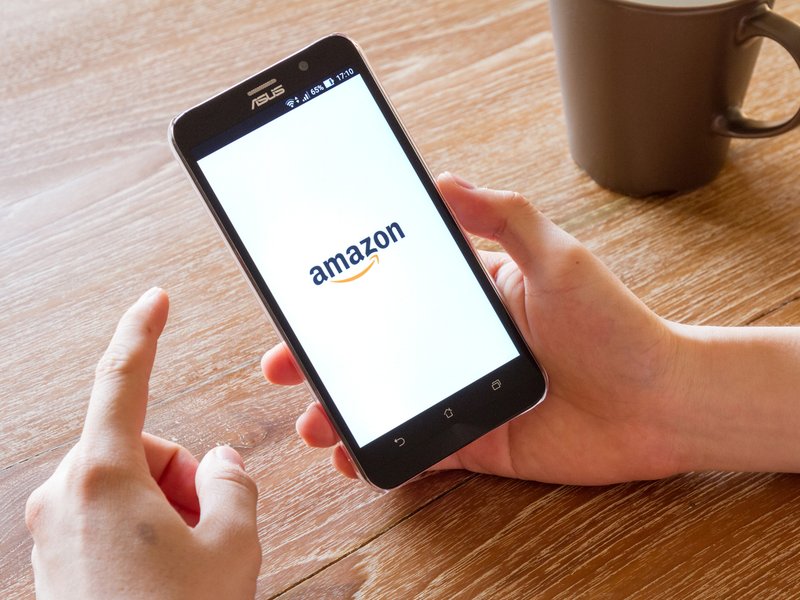 Man hand holding screen shot of Amazon