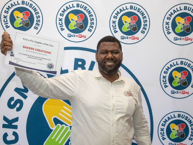 Man holding a certificate in his hand and smiling