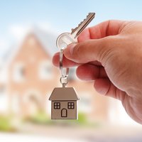 Man holding a key with a house key ring