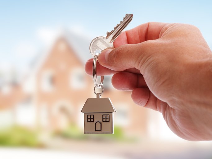 Man holding a key with a house key ring