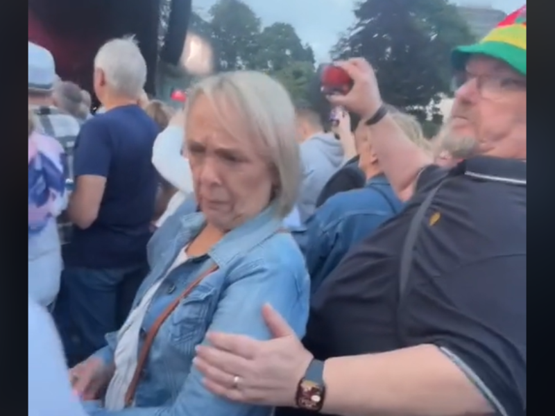 Man holds woman's arm at concert