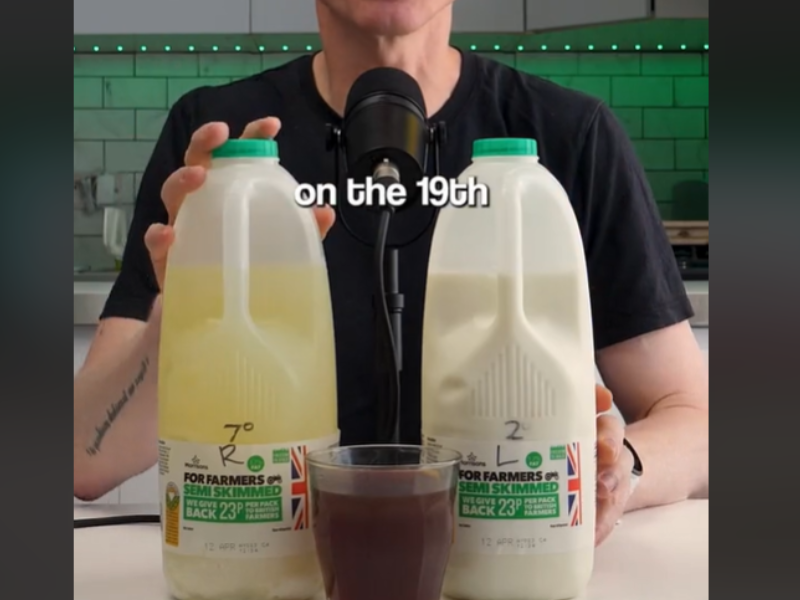 Man in kitchen with two bottles of milk