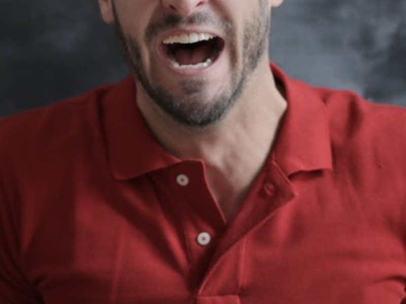 Man in red polo shirt with mouth open