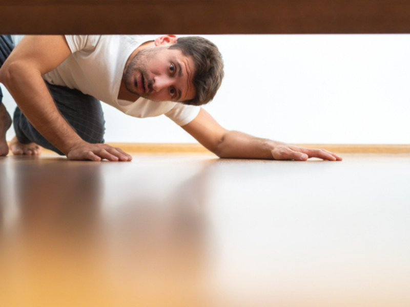 man looking under a bed