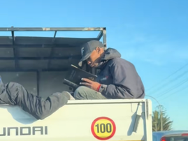 Man reading Bible on back of truck