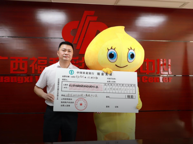 Man standing next to a mascot with winning lotto cheque