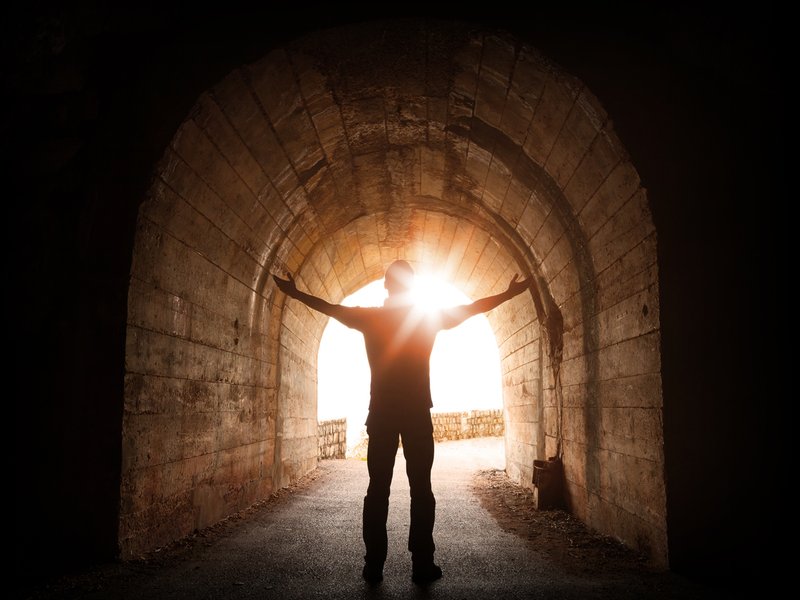 Man stands inside of old dark tunnel