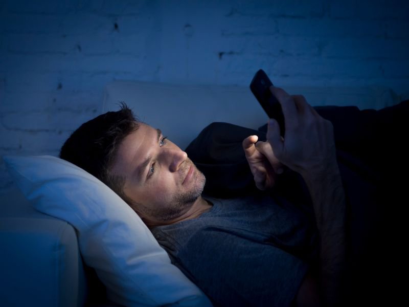 Man using phone in bed