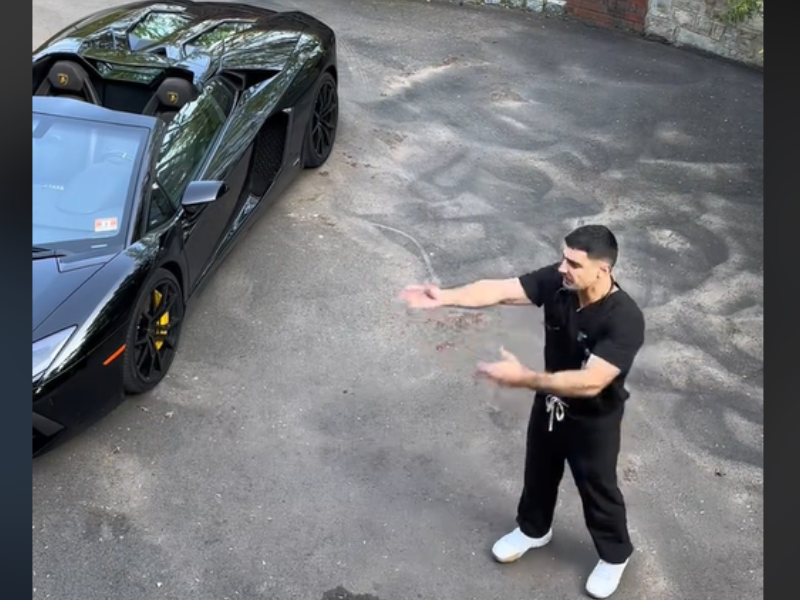 Man wearing scrubs standing next to a Lamborghini