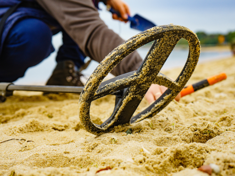 Man with metal detector on beach
