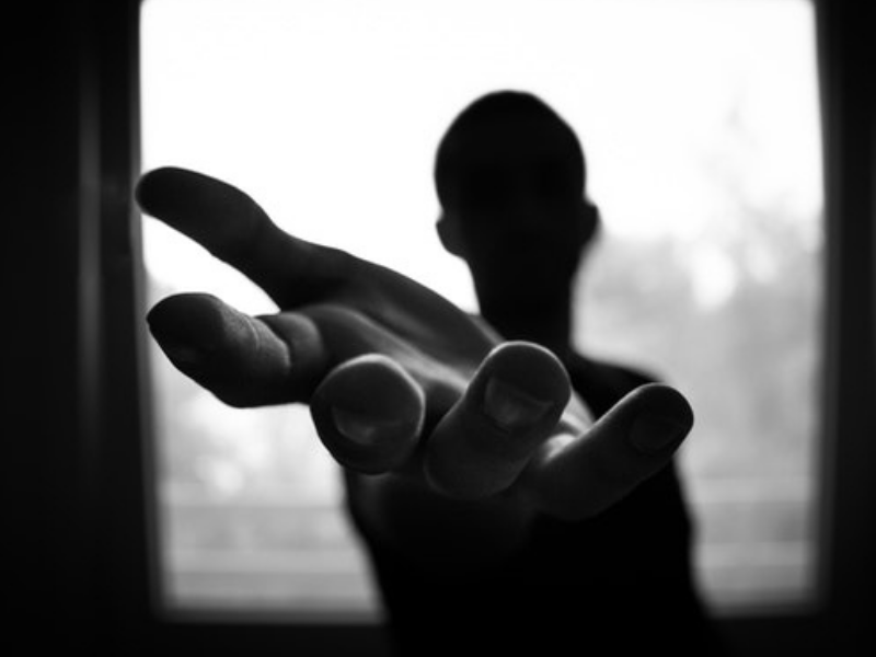 Man's hand in shallow focus and grayscale photography
