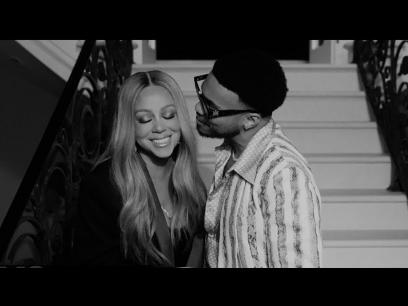 Mariah Carey and Anderson .Paak at the bottom of a staircase