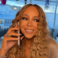 Mariah Carey holds a phone to her hear