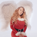 Mariah Carey wearing white angel wings and a Christmas