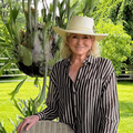 Martha Stewart poses outdoors in a green garden setting
