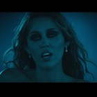 Miley Cyrus sings against a blue tinted background