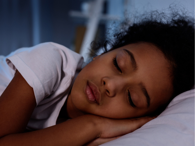 Mixed race kid sleeping peacefully in bed