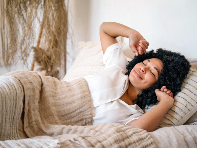Mixed race woman stretching after a day nap