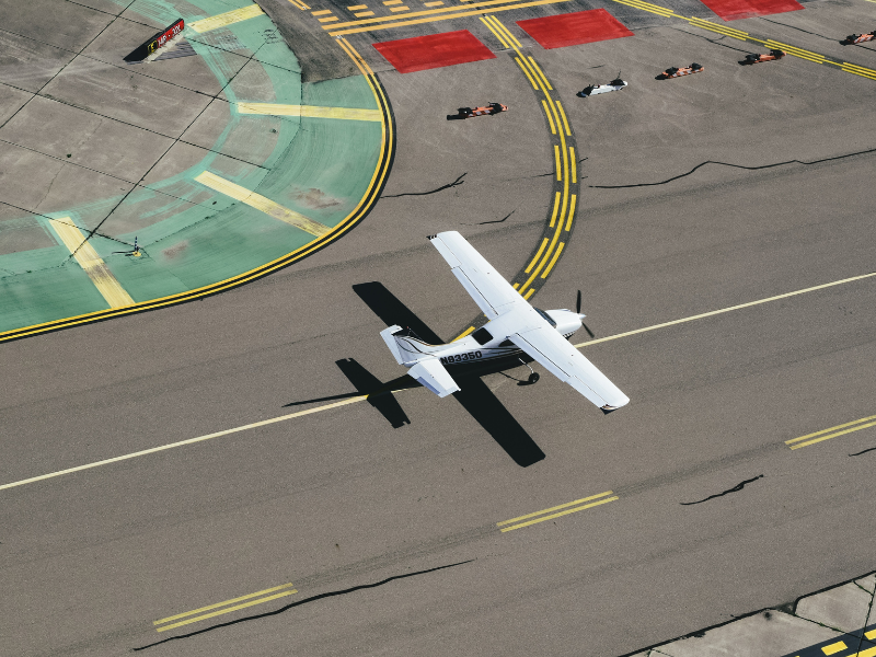 Modern white plane landing on asphalt airstrip