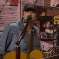 Morgan Wallen wearing a denim jacket while performing