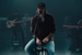 Morgan Wallen sitting on a stool while performing