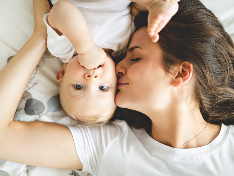 Mother and baby on bed