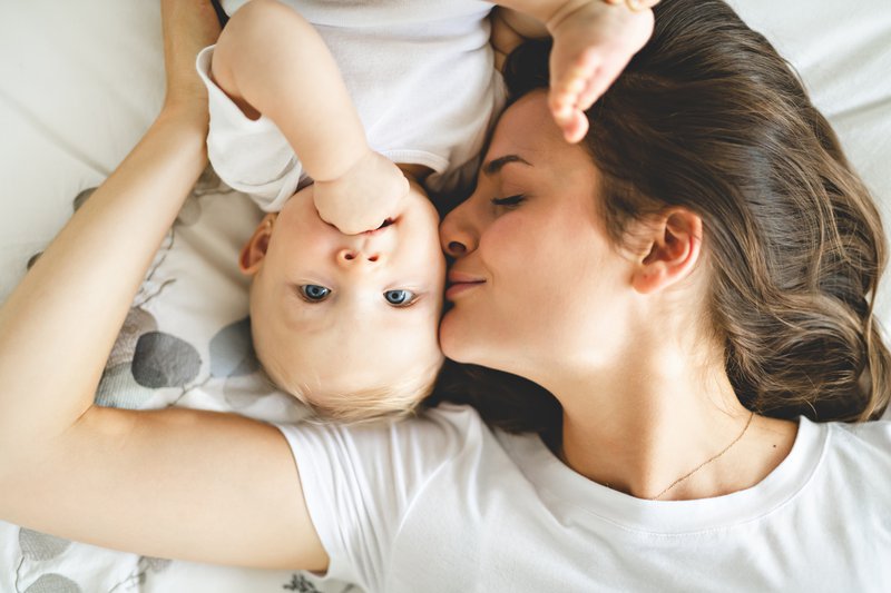 Mother and baby on bed